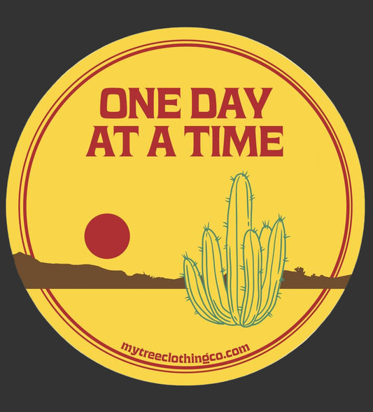 Original artwork for round sticker with cactus and 'One Day at a Time' text on a yellow background
