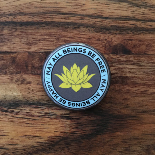 Round badge with lotus flower and text on a wooden surface