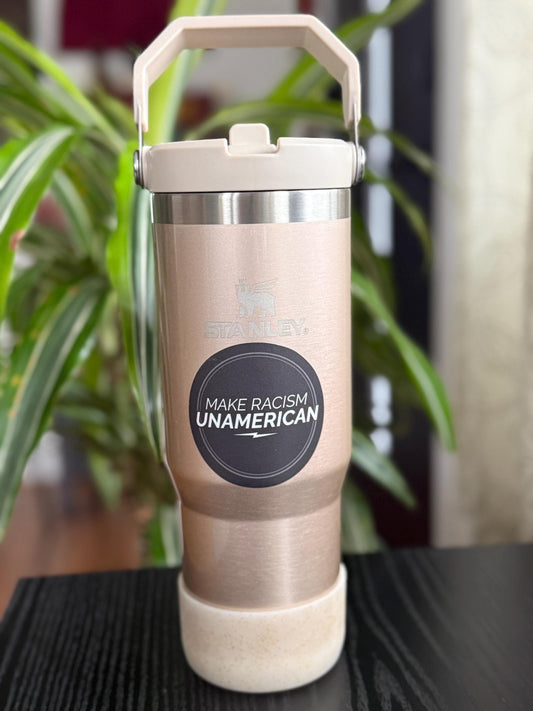 Metallic tumbler with a 'Make Racism Unamerican' label on a blurred background.