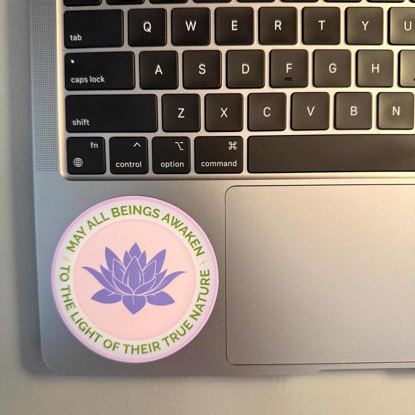 3" round sticker with a purple lotus flower design and the text, may all beings awaken to the light of their true nature, attached to a laptop.