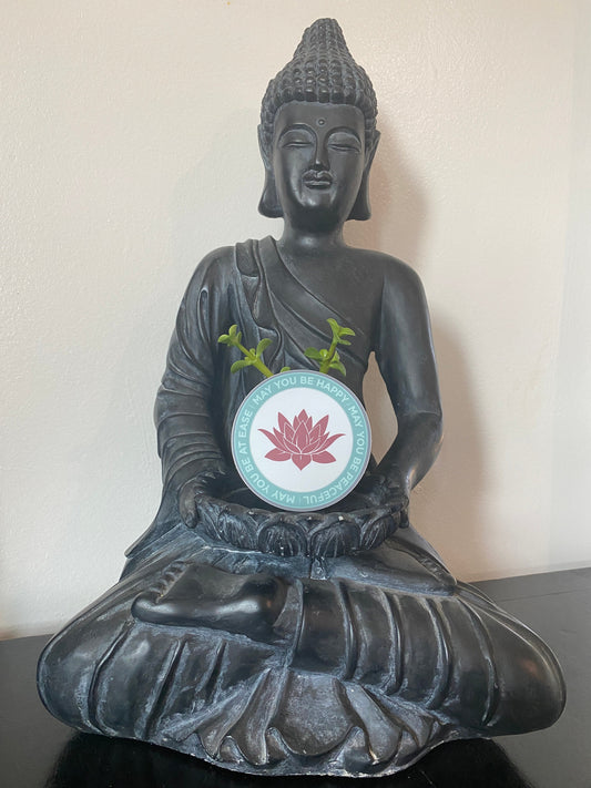 Black Buddha statue with an ultra thin magnet with pink lotus flower design and text, may you be happy may you be peaceful, may you be at ease.