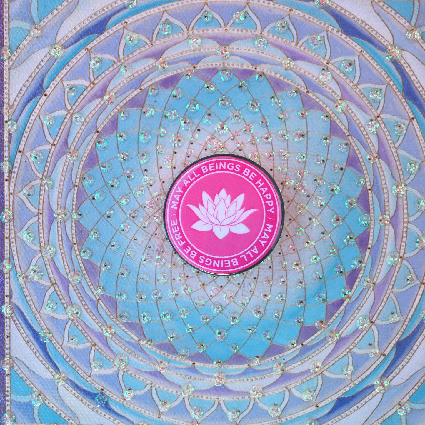 1.25" lotus button with the text, may all beings be happy may all beings be free in front of a mandala pattern.
