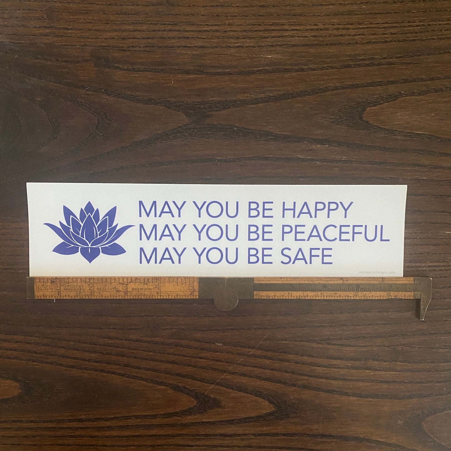White and blue buddhist prayer bumper sticker that reads, MAY YOU BE HAPPY MAY YOU BE PEACEFUL MAY YOU BE SAFE.