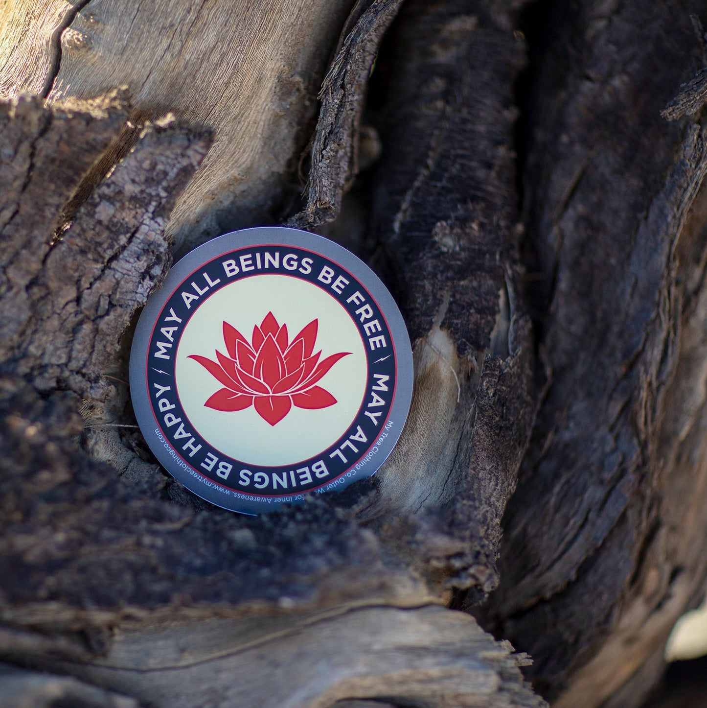 Round sticker with lotus flower design and text on a wooden surface