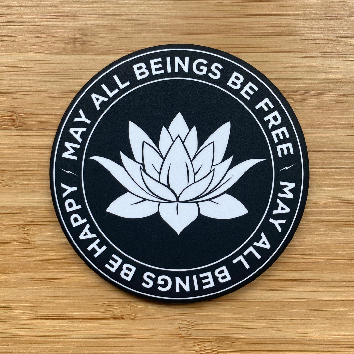 3.5" round black and white magnet with lotus flower design and text, may all beings be free, may all beings be happy.