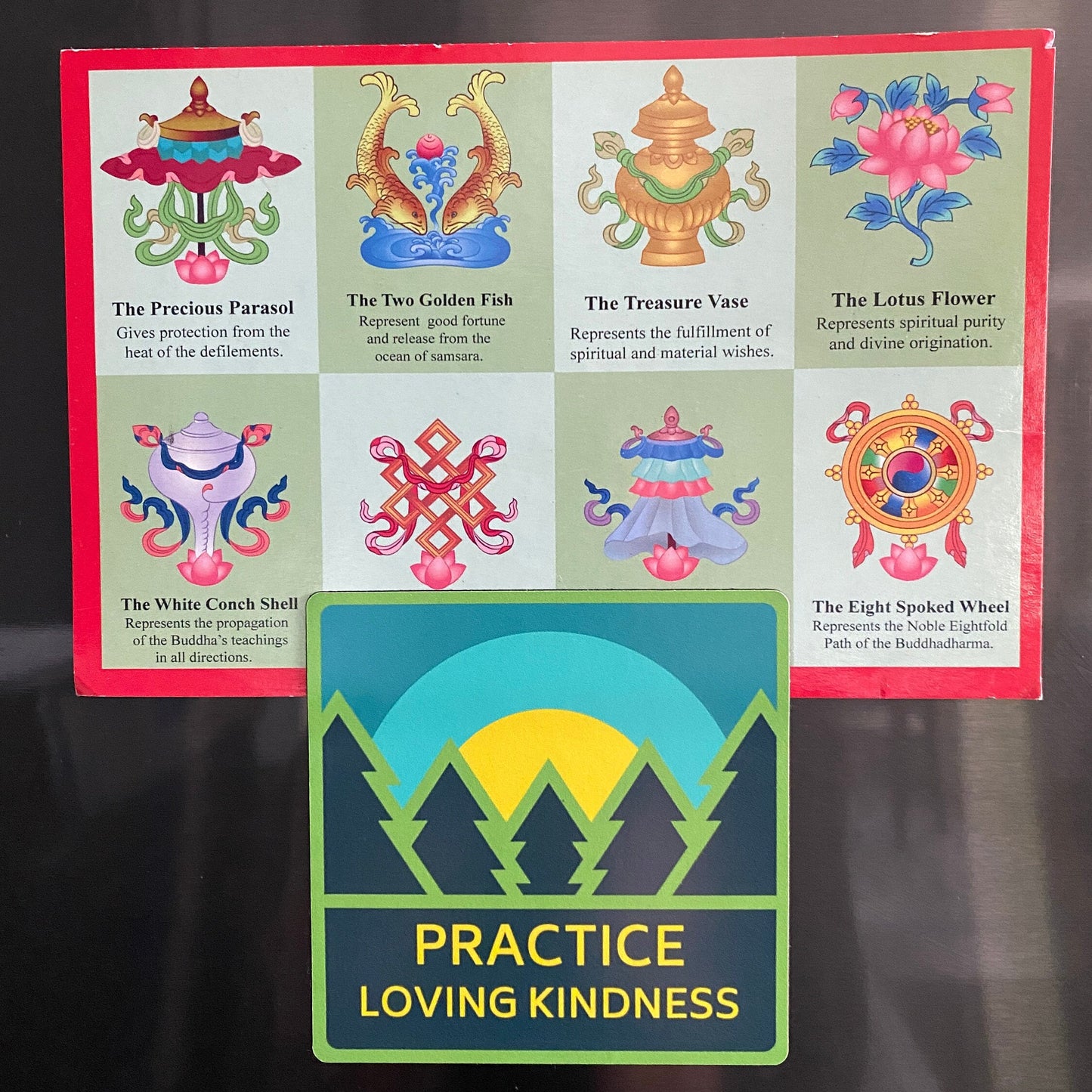 3" square sticker with trees and a sunrise and the text 'Practice Loving Kindness' attached to a refrigerator.