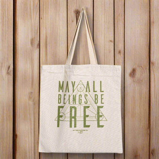 Beige yoga tote bag with green text, may all beings be free, with sacred geometry design.