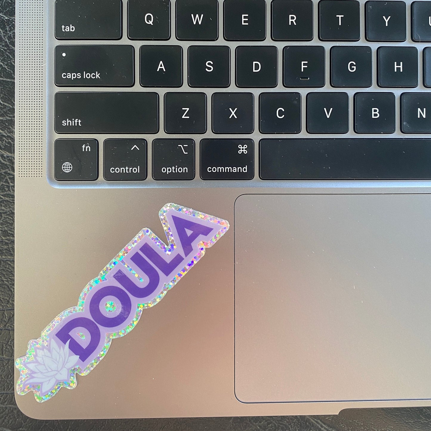 Laptop keyboard with a 'DOULA' sticker on the palm rest area.