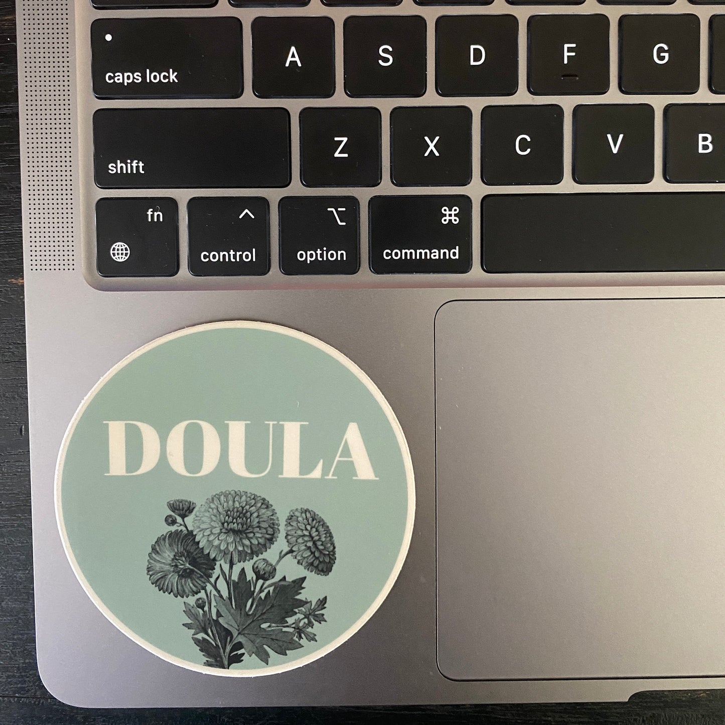Laptop with a 'DOULA' sticker on the palm rest area.