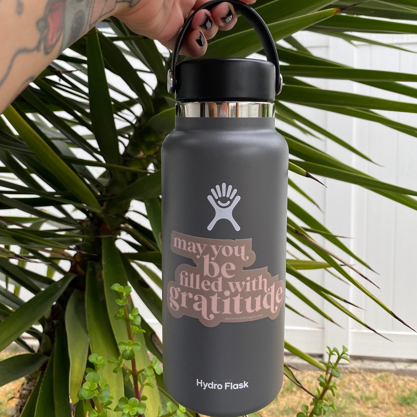 Hydro Flask water bottle with a pink and brown sticker that reads, may you be filled with gratitude.