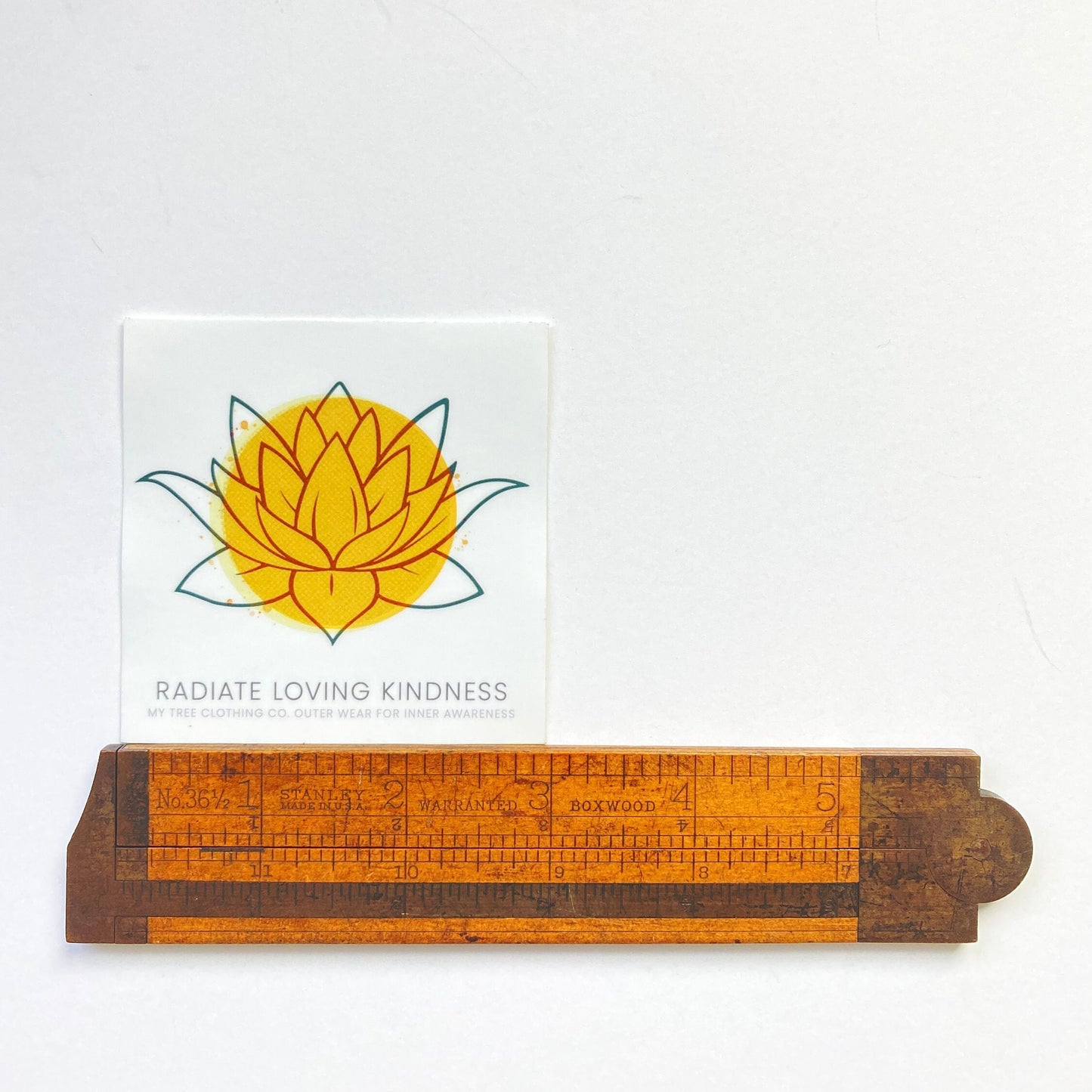 Wooden ruler with a yellow lotus flower design and 3" lotus 'Radiate Loving Kindness' text on a white background