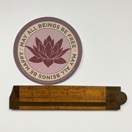 4" Circular sticker with magenta colored lotus flower design and the text, MAY ALL BEINGS BE FREE MAY ALL BEINGS BE HAPPY.