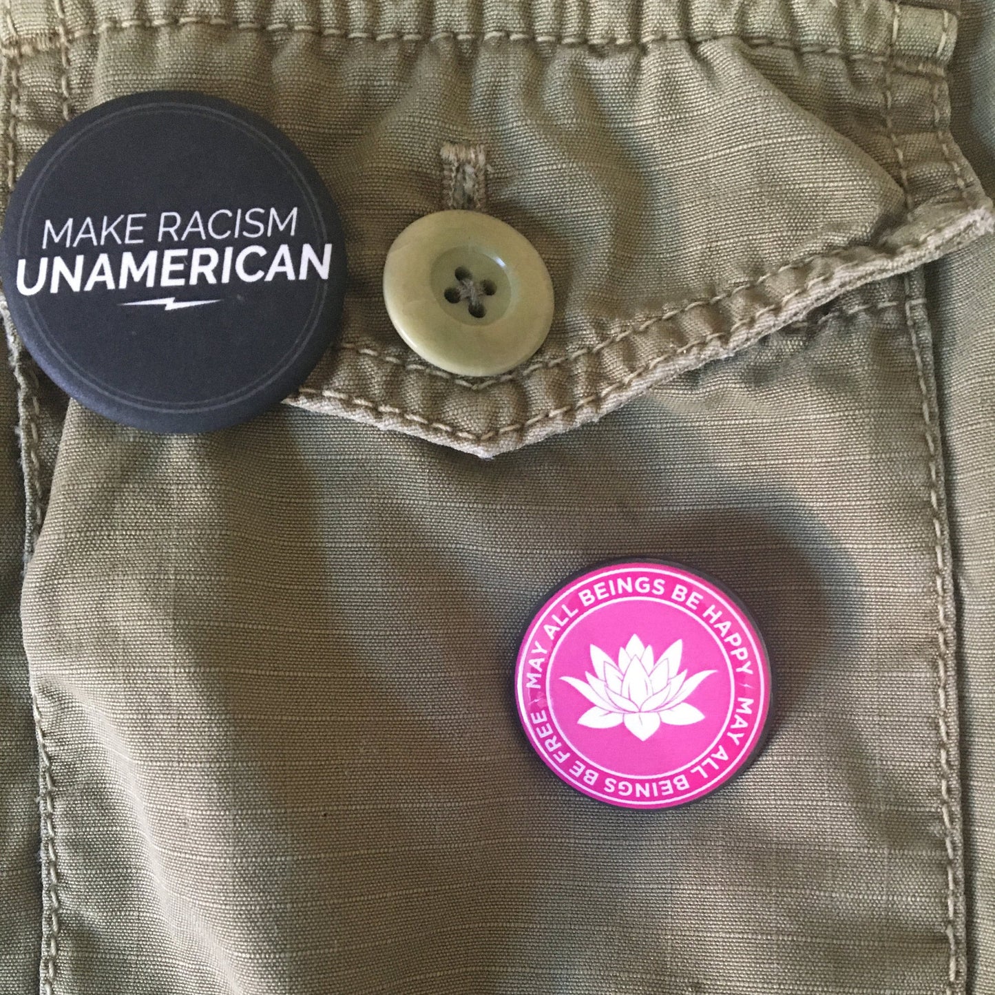 Button with 'Make Racism Unamerican' text on a jacket with a pink button featuring a lotus flower design.