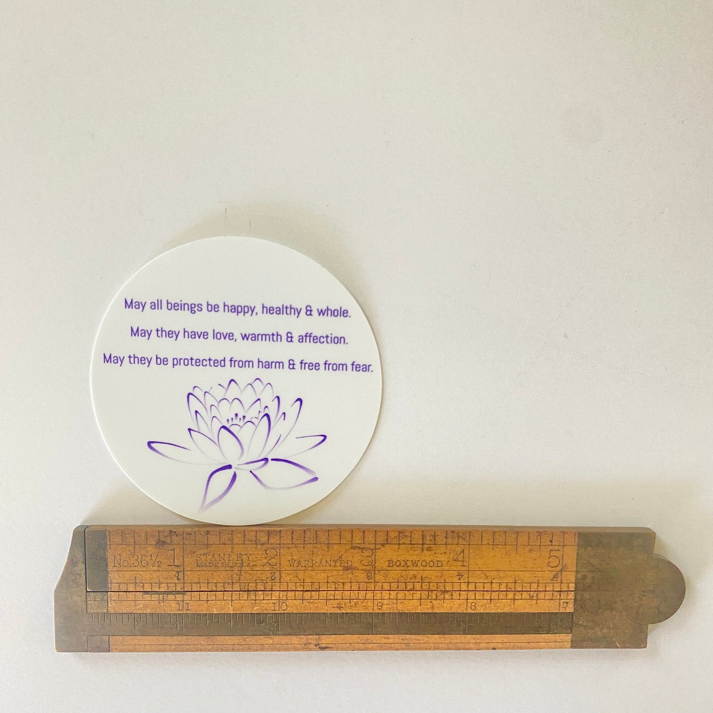3" circular sticker with Buddhist prayer and a lotus design.
