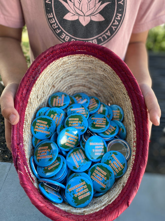 Person holding a woven basket filled with blue buttons.
