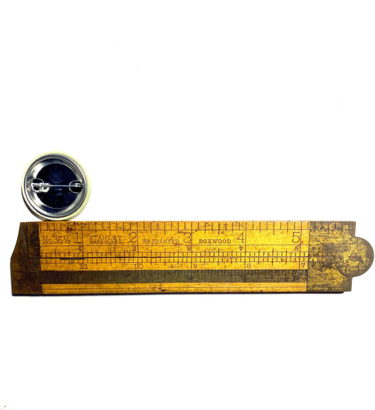 Small wooden ruler with a button on a white background