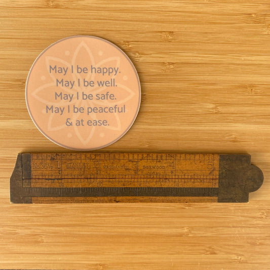 circular sticker with text, may i be happy may i be well may i be safe may i be peaceful may i be at ease.