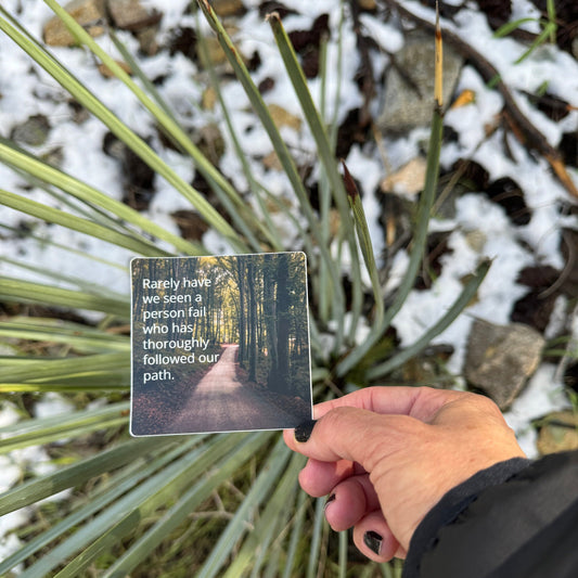 Hand holding a 3" square 12 step recovery sticker with a quote from the big book of alcoholics anonymous, 'rarely have we seen a person fail who has thoroughly followed our path.'