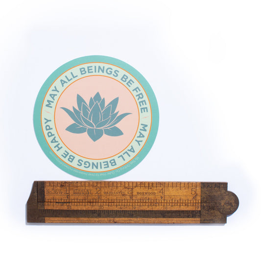 Wooden ruler with a circular design featuring a lotus flower and text on a white background