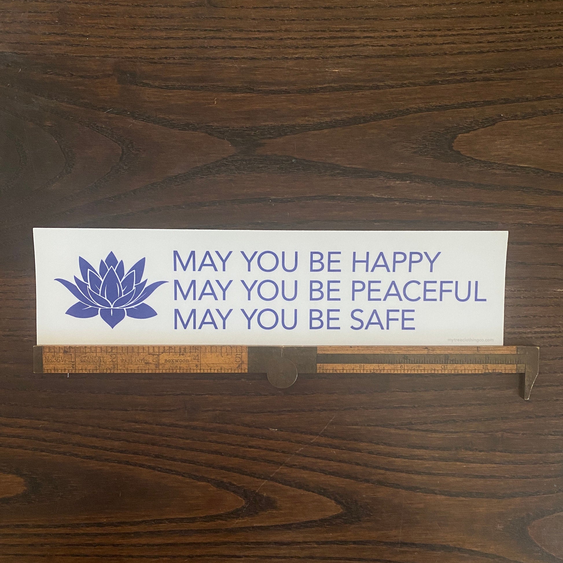 White and blue buddhist prayer bumper sticker that reads, MAY YOU BE HAPPY MAY YOU BE PEACEFUL MAY YOU BE SAFE.