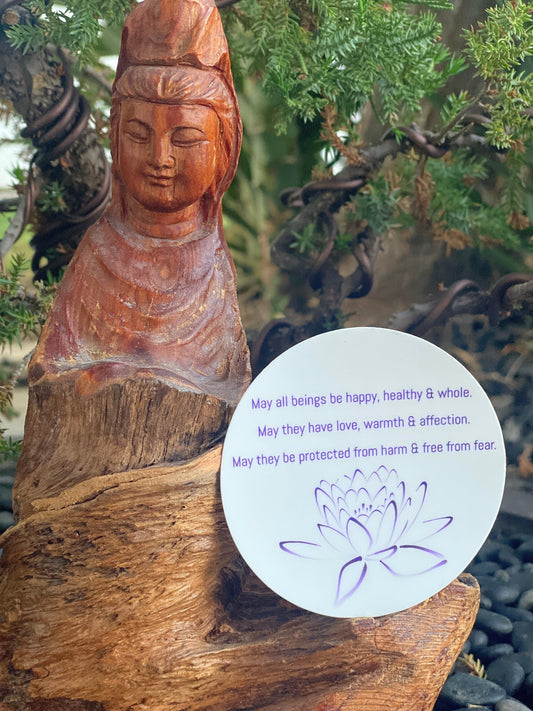 3" circular sticker with Buddhist prayer and a lotus design, set against a natural background.