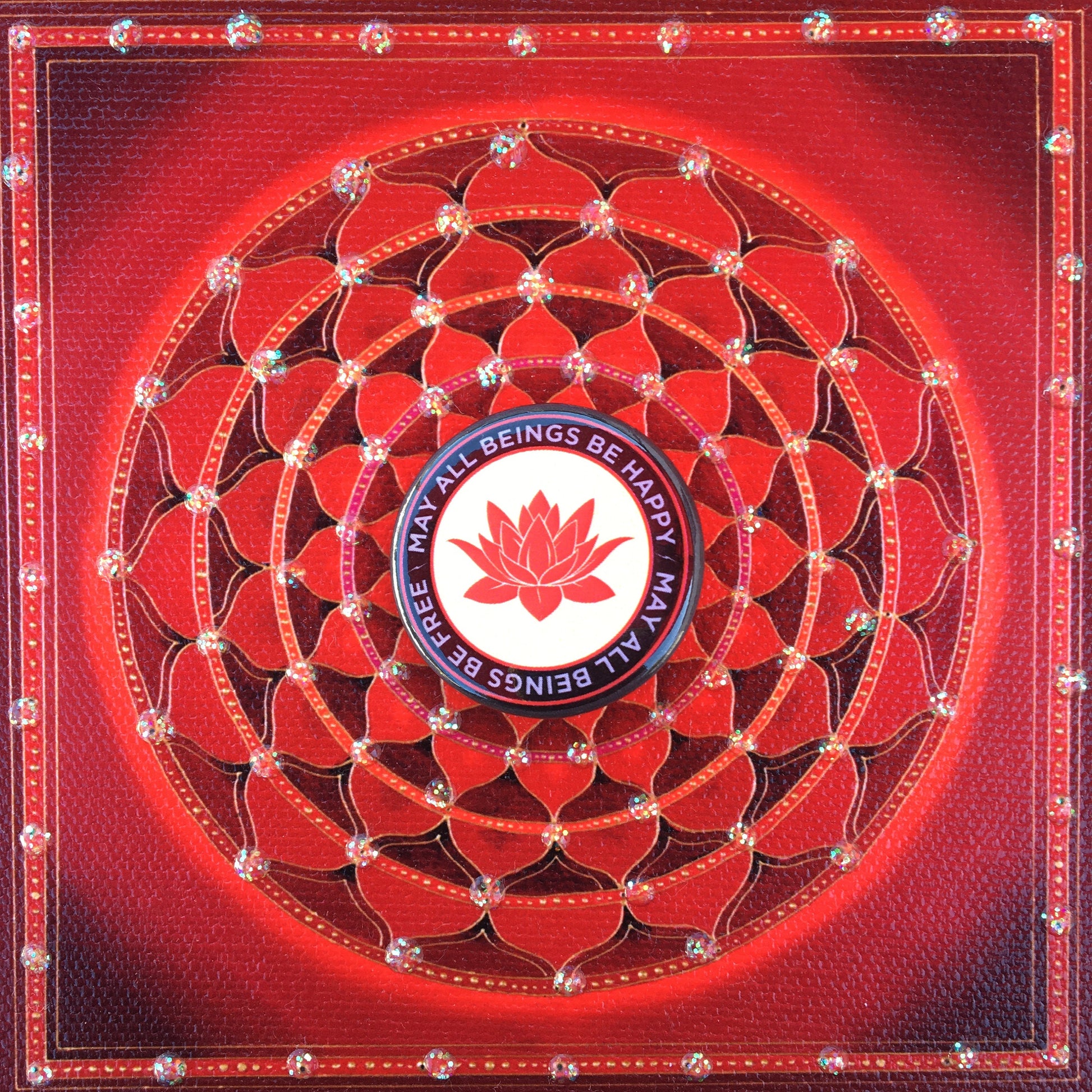 Decorative red mandala with a 1.25" pin back button with a red lotus flower design and the text, may all beings be free may all beings be happy.