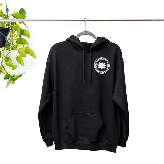 Black hoodie with a white lotus and the mettā prayer, 'may you be peaceful may you be happy may you be free.'