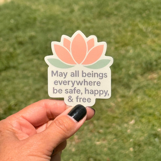 Die cut sticker with a pink lotus thats says, MAY ALL BEINGS EVERYWHERE BE SAFE, HAPPY, & FREE.