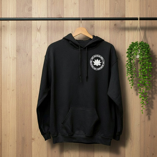 Black hoodie with a white lotus and the mettā prayer, 'may you be peaceful may you be happy may you be free.'